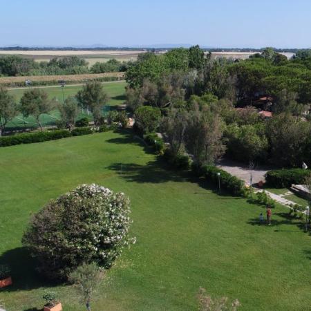 Aerial view of an orange building surrounded by gardens and trees.