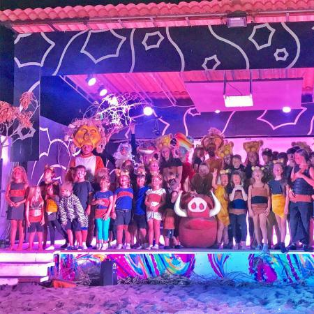 Group of children in costume on a colorful stage.