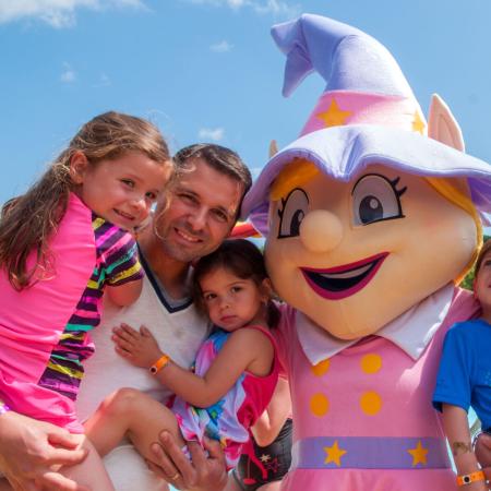 Happy family with a fairy costume at an amusement park.