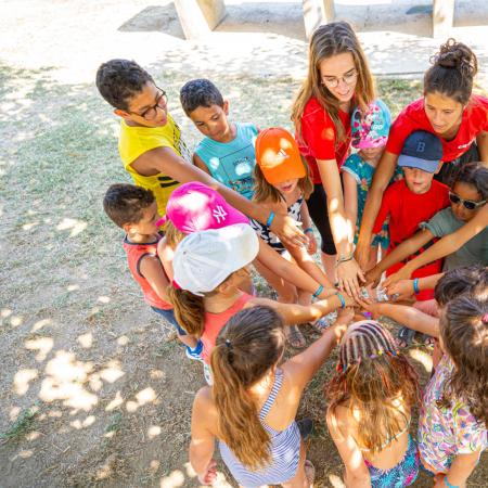 Children and leaders united in a circle outdoors.