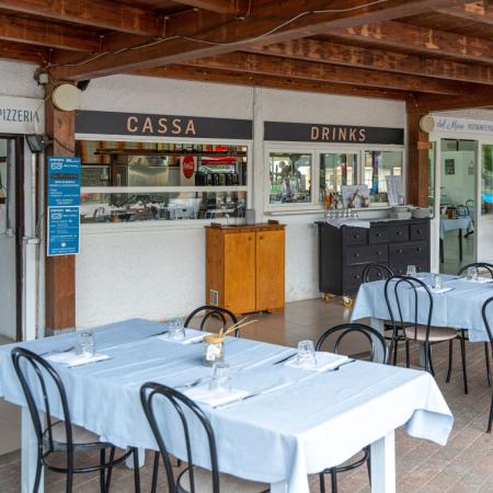 Outdoor restaurant with set tables and a cashier.
