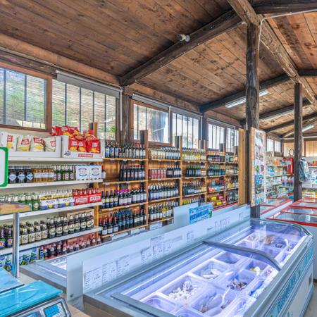 Supermarket with shelves of drinks and various products.