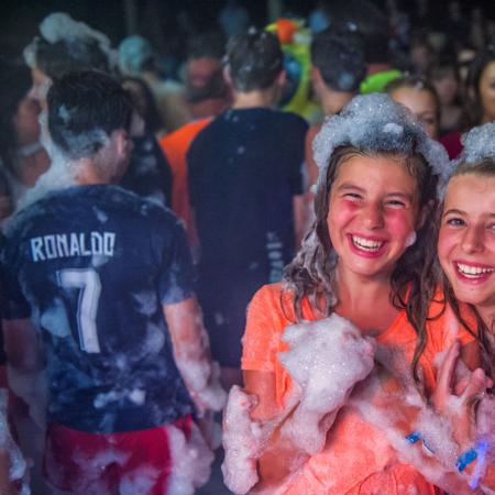 Smiling kids at a foam party.