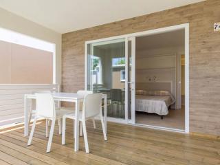 Terrace with white table and visible bedroom.