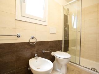 Modern bathroom with shower, bidet, and toilet.