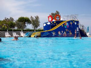 Pool with colorful slide and children's decorations.