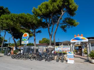 Entrance of SunBeach Camping Village with parked bicycles.