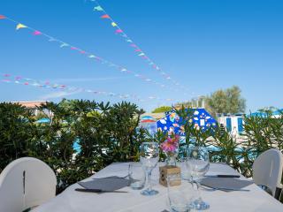 Set table with pool view and colorful decorations.
