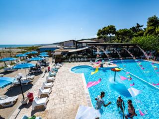 Outdoor pool with umbrellas and sea view.
