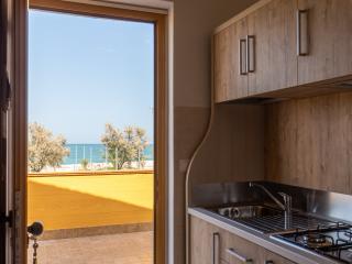 Kitchen with sea view through an open door.