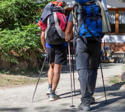 Due escursionisti con zaini camminano su un sentiero di montagna.