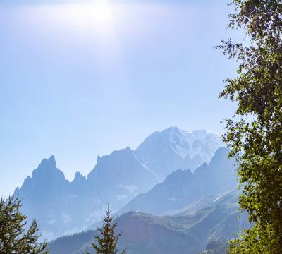 Campeggio pittoresco con roulotte e montagne sullo sfondo.