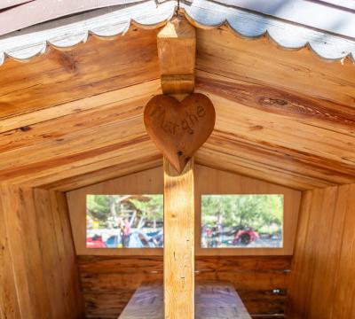 Interno di una capanna di legno con cuore inciso 'Marghe'.