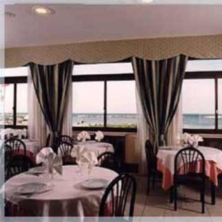 Elegant restaurant with sea view, tables neatly set.