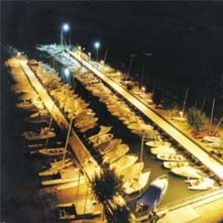 Marina illuminated at night with docked boats.