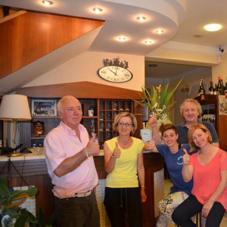 Happy group in a bar, giving thumbs up.