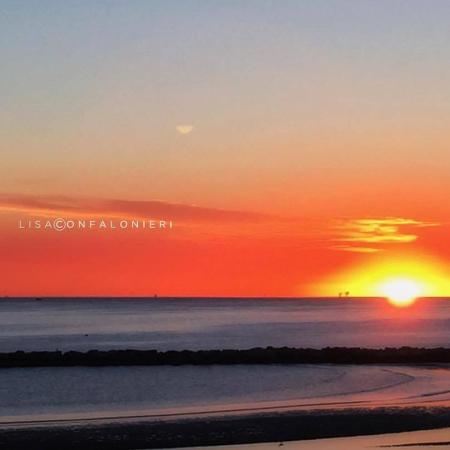 Sunset over the sea with orange and blue sky.