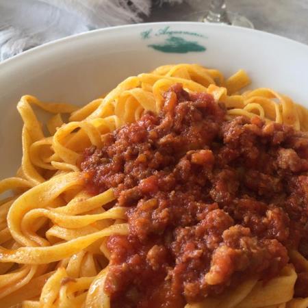 Tagliatelle with ragù served in a white plate.