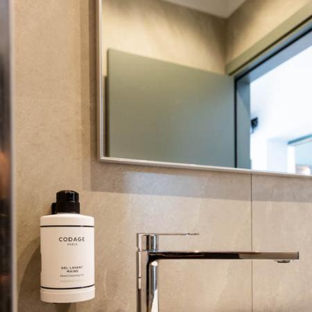 Elegant bathroom with Codage soap and modern faucet.