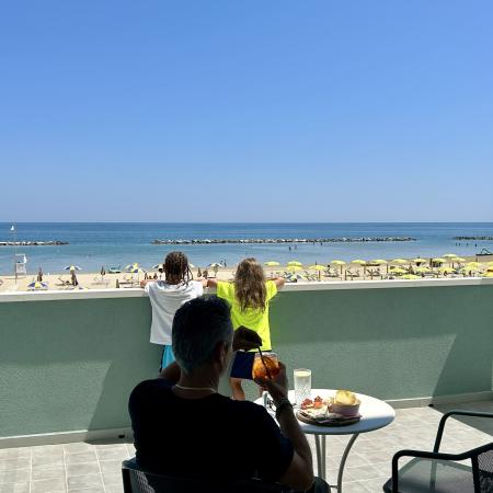 Sunny beach, calm sea, relaxing with a drink and breathtaking view.