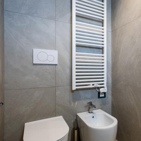 Modern, cozy bathroom with white fixtures and wooden details.