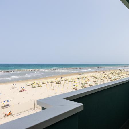 Breathtaking sea view from a balcony, golden beach and colorful umbrellas.