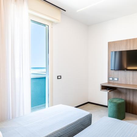 Bright room with sea view, TV, and minibar.