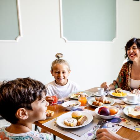 Happy family at breakfast, laughter and delicious food.
