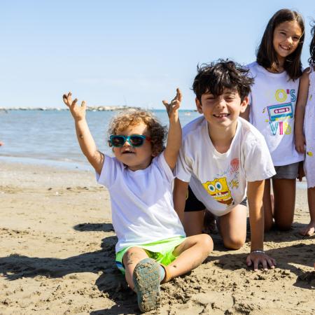 Smiling children joyfully play on the sunny beach.