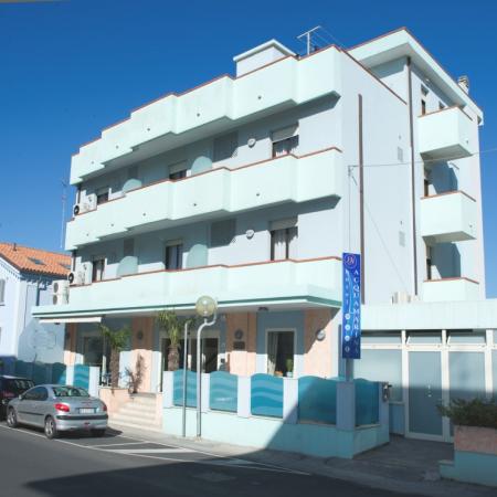 Modern three-story hotel with balconies and blue sign.