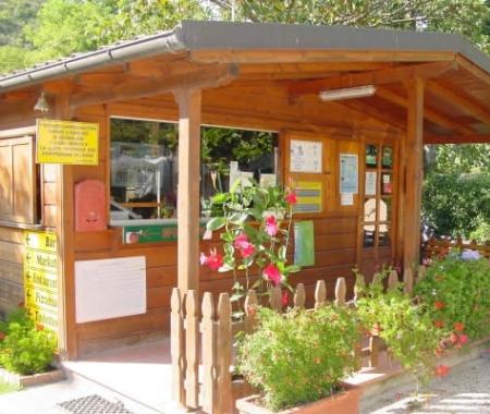 Maison en bois avec des plantes et des panneaux d'information.