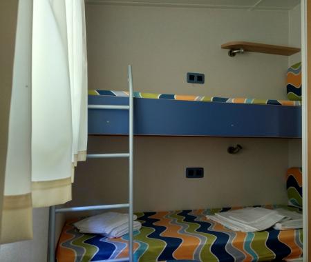 Bunk bed with folded sheets in a simple room.