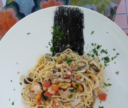 Seafood spaghetti with a squid ink decoration.