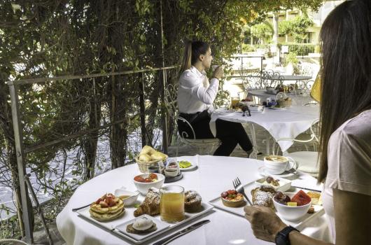 Colazione all'aperto con dolci e caffè, atmosfera rilassante.