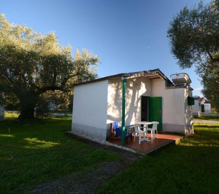 Kleines weißes Haus mit Veranda im Garten.