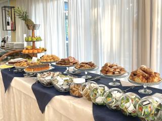Dessert and fruit buffet with jams and croissants.