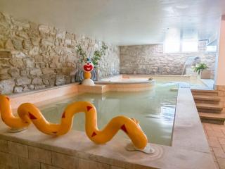 Indoor pool with colorful decorations and stone walls.