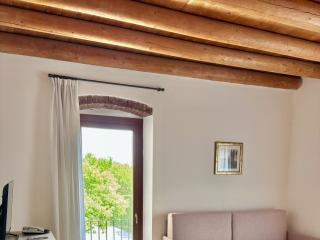 Bright living room with exposed beams, wooden table, and sofa.