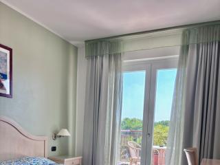 Bright room with double bed and balcony.
