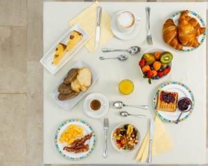 Colazione varia con frutta, croissant e caffè.