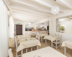 Sala da pranzo luminosa con tavoli apparecchiati e buffet.