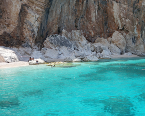 Spiaggia nascosta con acque turchesi e scogliere imponenti.