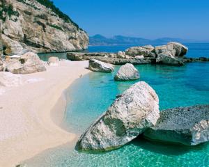 Spiaggia con acque cristalline e rocce bianche.