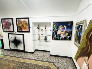 Galleria d'arte vibrante con dipinti astratti e ritratti colorati.