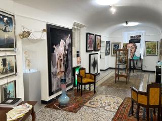Galleria d'arte colorata e accogliente, con mobili antichi e opere vibranti.