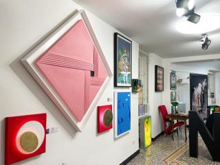 Galleria d'arte vibrante con opere astratte colorate e arredi eleganti.