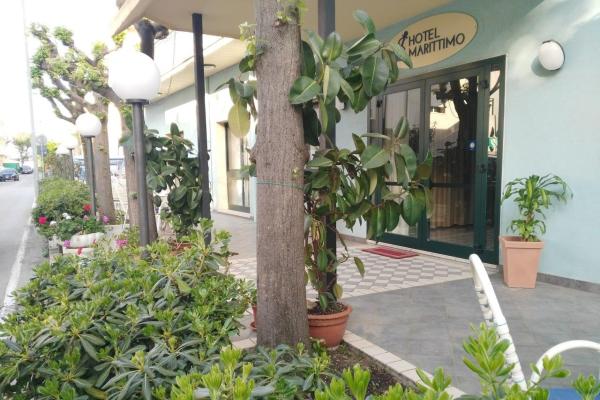 Ingresso dell'Hotel Marittimo con piante e lampioni.