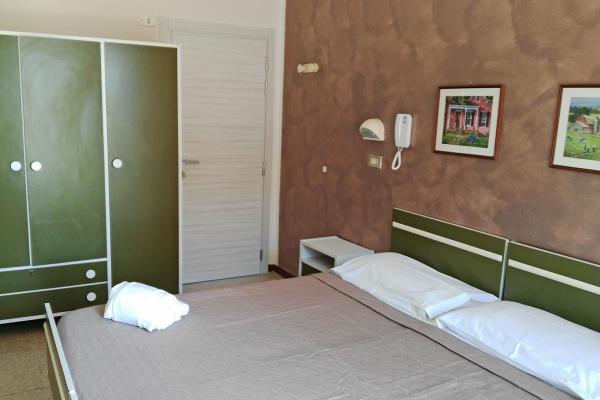 Camera da letto con armadio verde e letto matrimoniale.