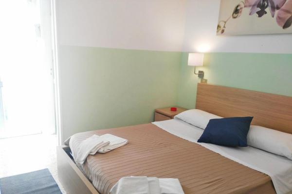 Camera da letto moderna con letto matrimoniale e decorazioni semplici.