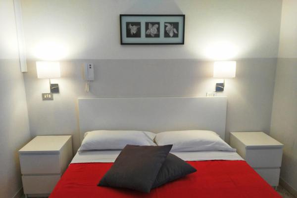Camera da letto moderna con letto matrimoniale e comodini.